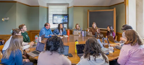 Professor Cdebaca listening to students during class.