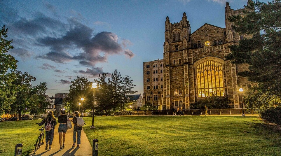Students walking outside of the Michigan Law Reading Room at sunset.