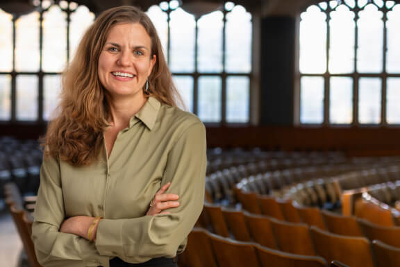 Alma Diamond smiles with arms crossed in a Law School classroom.