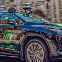 Action shot of an autonomously driven car passing in front of Michigan Law buildings