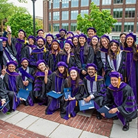 A group of Michigan Law Graduates pose for a graduation photo at the University of Michigan Diag.