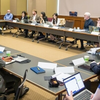 Participants gather around a table at a conference.