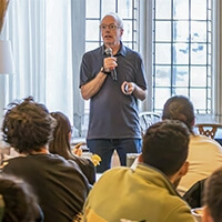Professor Dave Moran speaks in front of a large group.