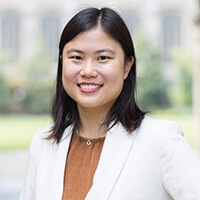 Michigan Law professor Belisa Pang stands under a Lawyers Club archway.